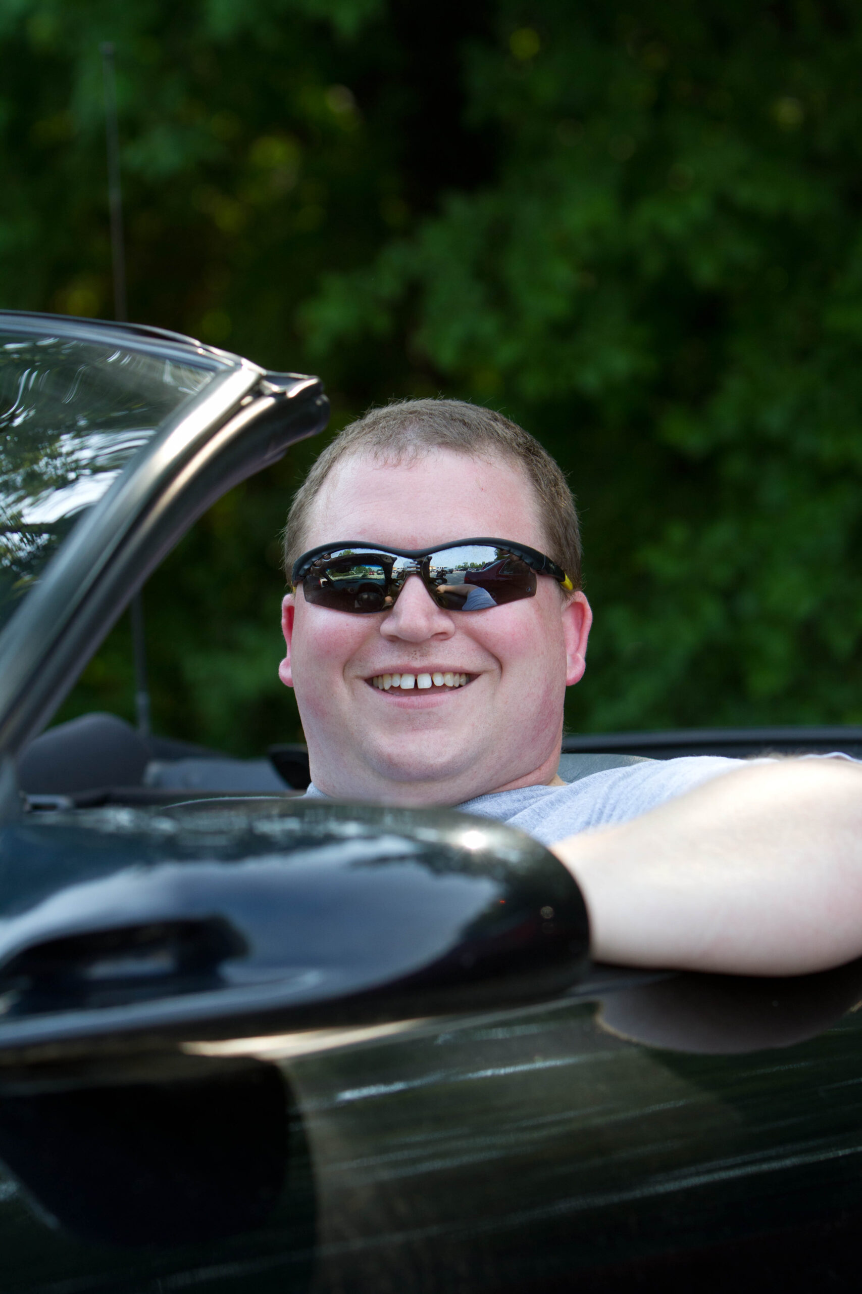 Photo of the author wearing sunglasses driving a car.