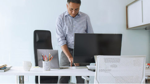 رجل يقف في مكتب اثناء الكتابة علي لوحه مفاتيح الكمبيوتر