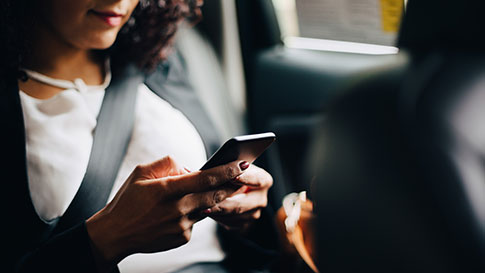 Kobieta w taksówce patrząc na jej telefon