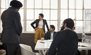 A group meets around a table in a meeting room.