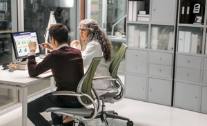 Image of two firstline workers collaborating at a desk in an office space.