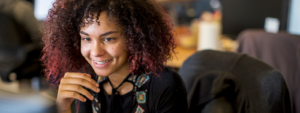 Image of a worker smiling at her computer.