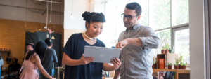 Image of two firstline workers collaborating over a laptop.