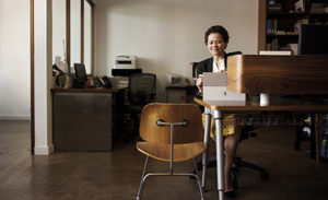 Image of a worker in her office working on a laptop.