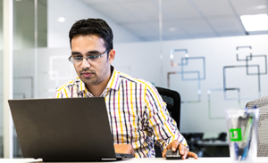 Image of a man at work in front of a laptop.