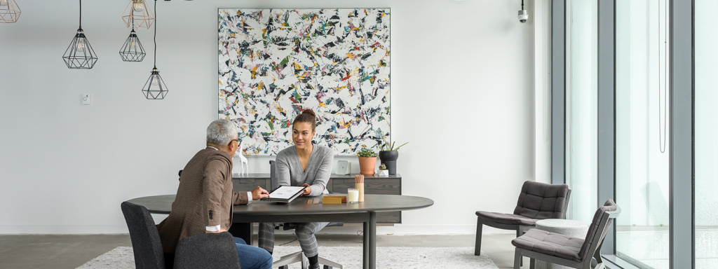 Two Firstline Workers interact with one another over a table.