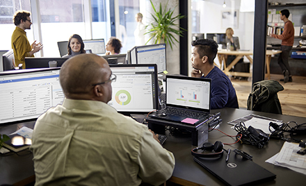 Image of tech workers working at a desk.