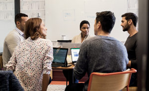 A team sits around a table at a meeting.