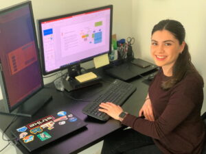 Marcela Alvarez Rodriguez sits at a desk, working on her computer.