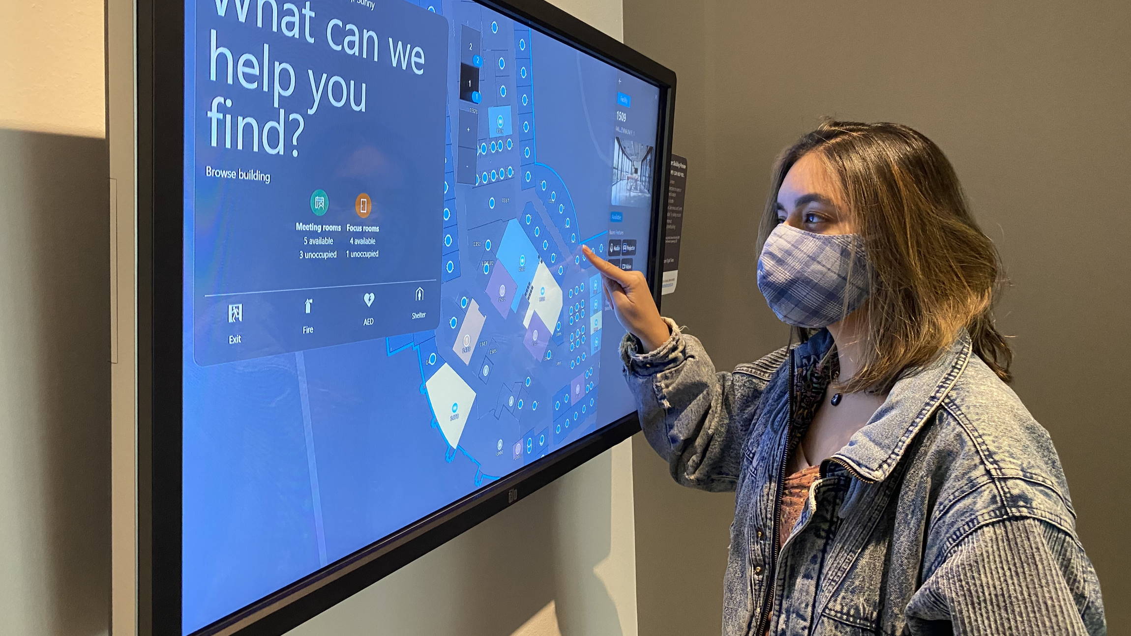 Ansari interacts with the screen of a SmartBuilding services kiosk in the lobby of a Microsoft building.