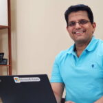 Venkatraman smiles at he sits in front of his laptop at his desk in his home office.