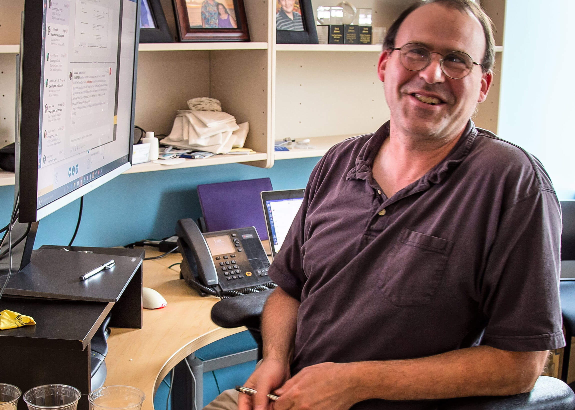 Johnson smiles as he sits working at his desk in his office at Microsoft.