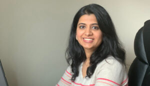 Anawalikar smiles at the camera as she sits at her desk.