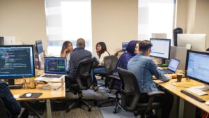 A team at Microsoft works together in a cluster of desks in a Microsoft office.