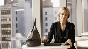 A worker sits at a table in an open office space.