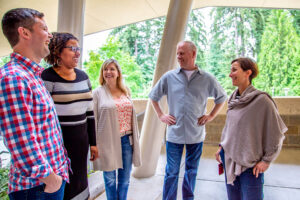 Bill Lincoln, Cassandra Young, Rebekah Hankins, Kurt Hughes, and Liz Friedman share a laugh in a photo taken outside.