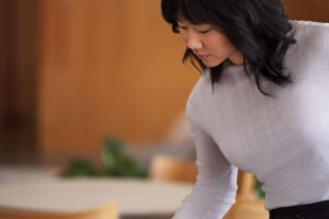 A Microsoft employee collaborates with a colleague as they sit in front of their PCs in an open workspace.