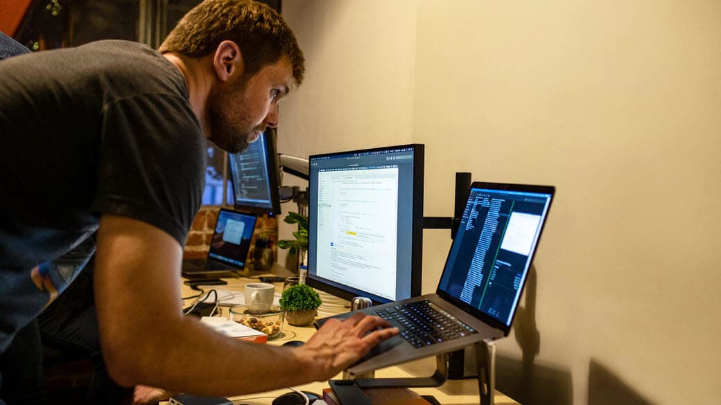 Male developer working while standing at his desk.