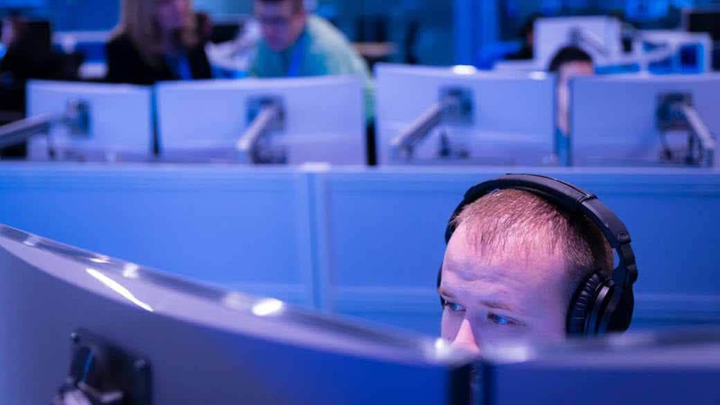 Man working while wearing headphones in the Microsoft Cyber Defense Operations Center.