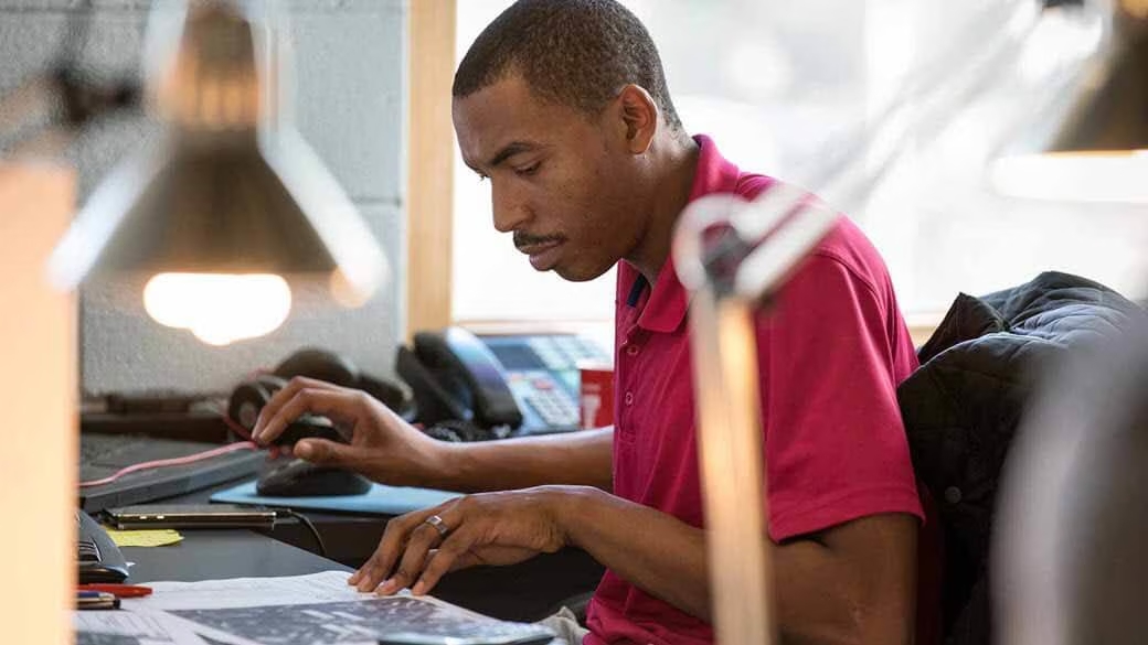 Man studies paper on desk.