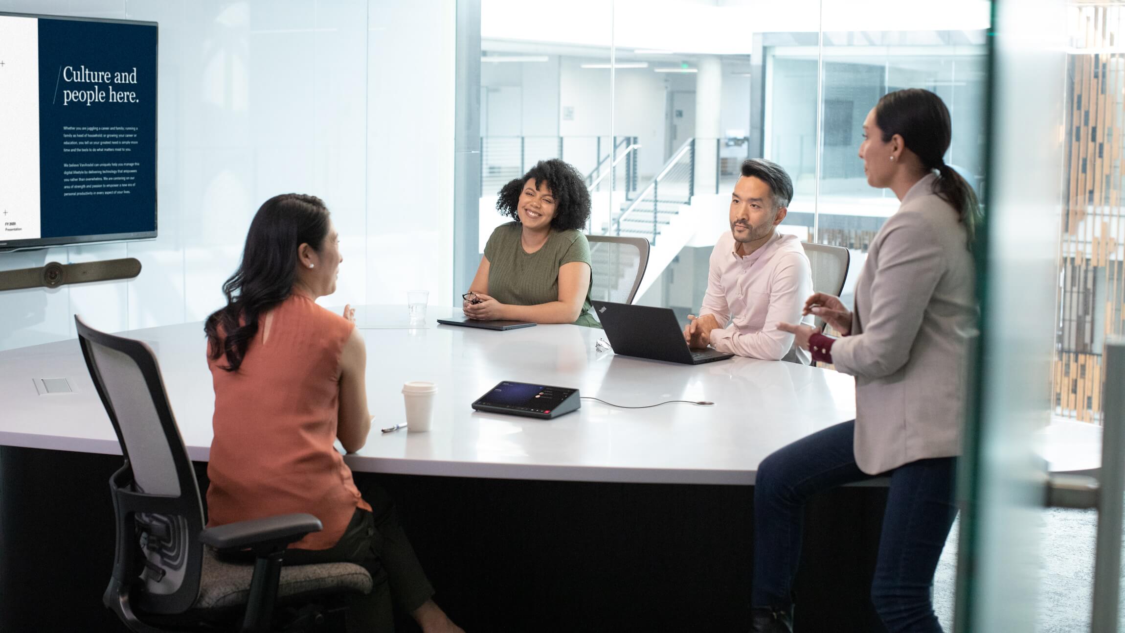 A Microsoft employee delivers a presentation on people and culture to three colleagues.