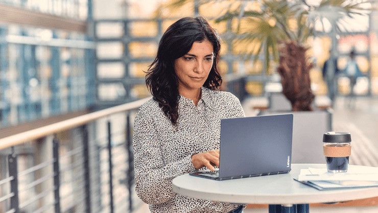 Woman at table using laptop.