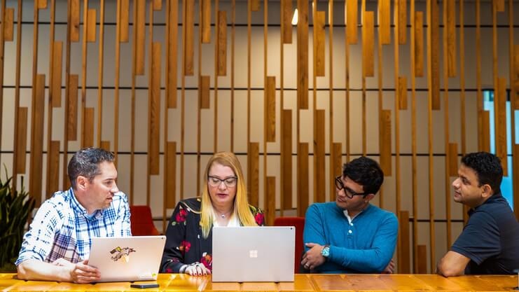 Microsoft employees gathered in a hybrid workspace.