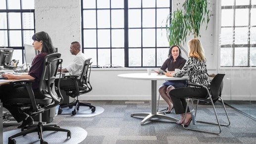 Open office with two women working at a table.