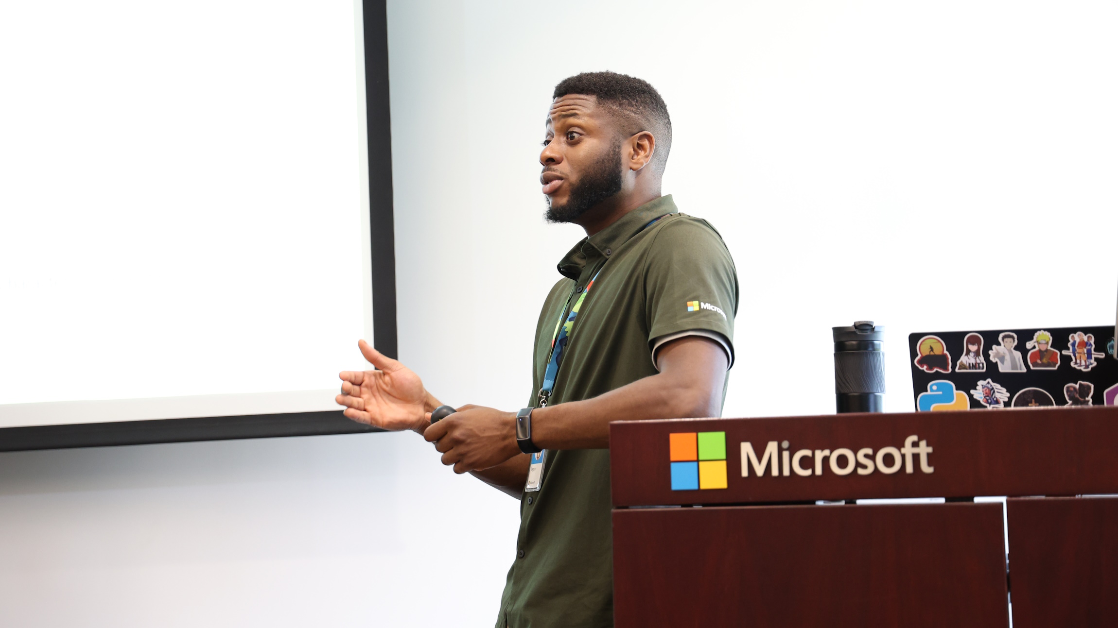 Akinyemi stands in front of a room speaking to students.