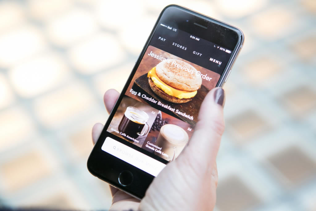 A smart phone displays personalized recommendations to customers via a mobile app