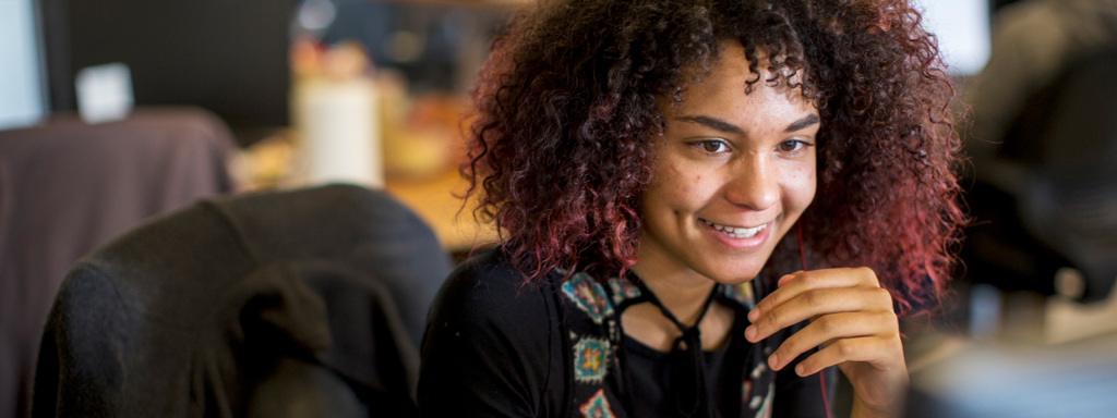 Image of a worker smiling at her computer.