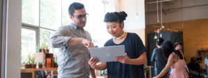 Image of two firstline workers collaborating over a laptop.