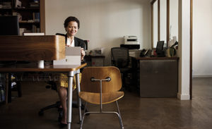 Image of a worker in her office working on a laptop.