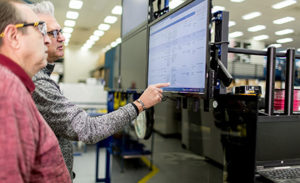 Image of two workers looking at a computer screen.