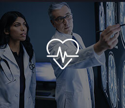 Two doctors looking over brain scans in a clinical setting with a heart beat icon overlaid on the image.