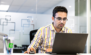 Image of a man at work in front of a laptop.