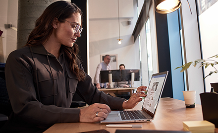 Image of a worker looking at a laptop on her desk.